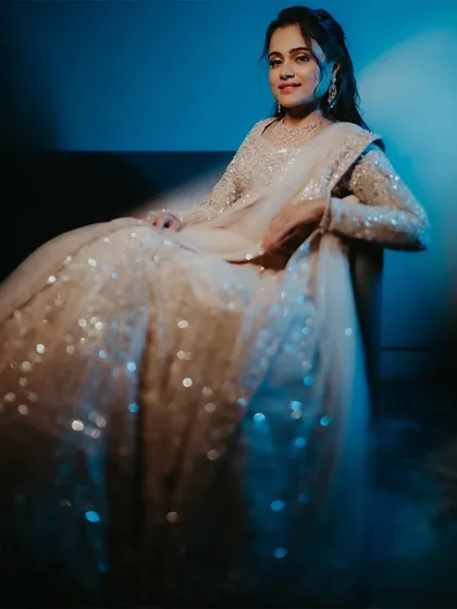 A bridal portrait using blue light and a slow shutter to create a soft, glittering effect on her sequined lehenga.