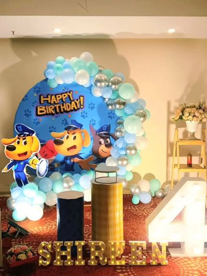 A cute Paw Patrol themed birthday party. This setup includes character cutouts, a custom 'Happy Birthday' backdrop, and a large marquee number '4'.