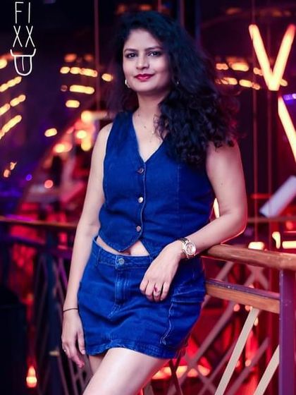 A stylish partygoer against the vibrant backdrop of The Fixx.