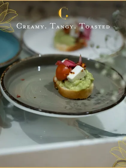 A perfect welcome bite for any corporate soirée. This appetizer features creamy avocado and tangy cream cheese on a toasted crostini, garnished with fresh tomato and paneer for a multi-layered flavour experience.