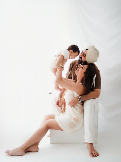A playful family moment, with dad lifting the baby high in the air. Pure happiness!