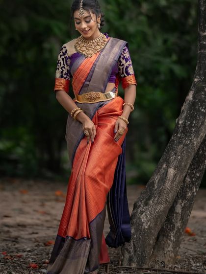 A full-length view of the orange and purple saree, showcasing its beautiful drape and unique color combination.