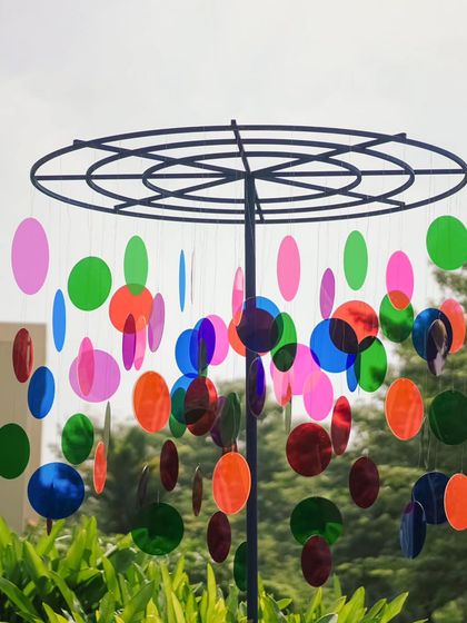 Another hanging mobile made of colorful acrylic discs, which spun and reflected the light, adding movement and vibrancy to the poolside decor.