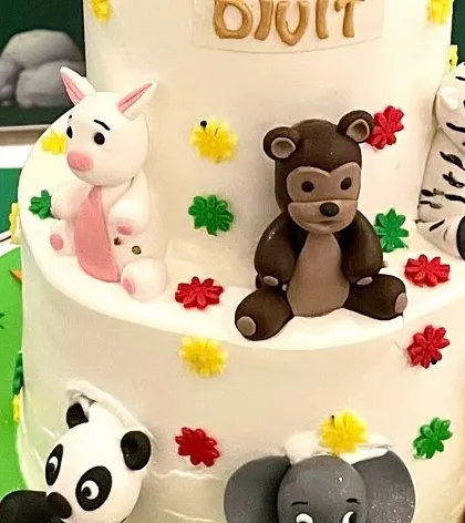 More details from the custom cake, with cute fondant animals like a pig, monkey, and elephant.
