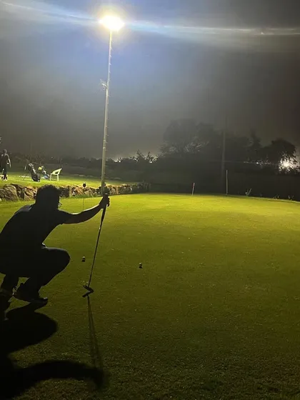 A player lines up a putt under the lights. Our well-lit short game area allows you to practice every aspect of your game at night.