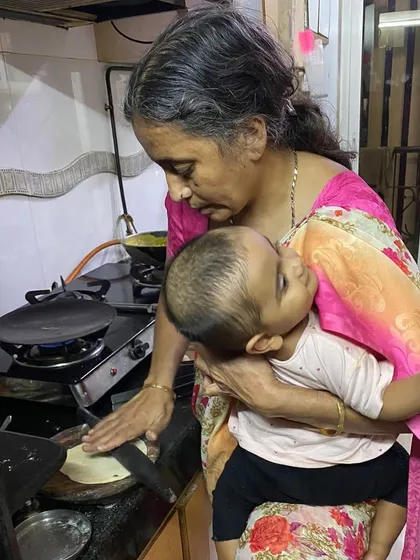 This photo of my mother-in-law is so special to me. It shows her incredible strength and nurturing spirit, calming her grandchild while cooking. She is the powerhouse of our family.