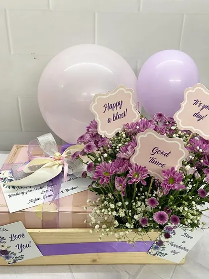A lovely birthday or appreciation hamper in shades of lavender, complete with balloons, flowers, and personalized cards.