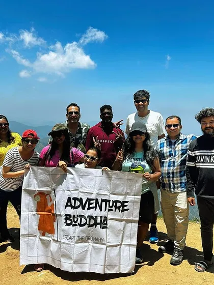 Our group on a sunny day in Kodaikanal, holding the banner high on a mountain top.