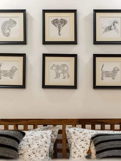 A gallery wall of intricate, black and white animal drawings above a bed, showcasing a love for art and nature. This simple yet effective decor adds a sophisticated and personal touch to the room.