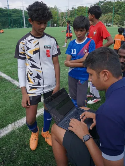 A coach records player data on a laptop during the U12 & U14 trials, ensuring our scouting process is thorough and organized.