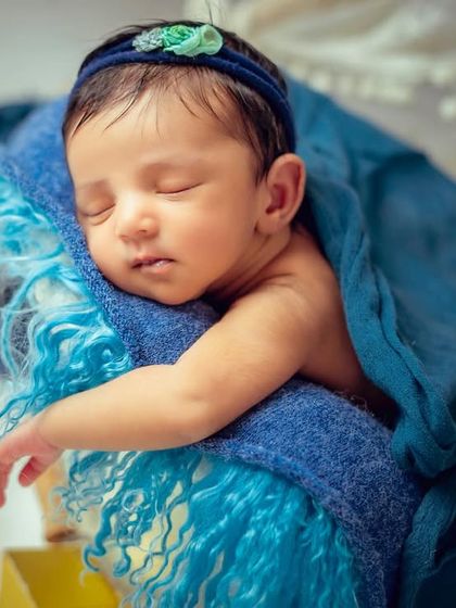 A close-up of the baby in the starry night setup, showing the soft blue textures and the baby's peaceful expression.