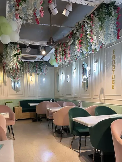 For this cafe in G.K. 1, I created a light and airy atmosphere using a pastel color palette. The design features pink and green velvet chairs, elegant wall molding, and floral ceiling installations to craft a whimsical and memorable dining experience.