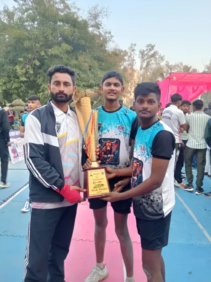 Here I am with two of my players and their hard-earned trophy. Moments like these make all the hours of coaching and practice worthwhile.