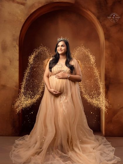 An ethereal portrait of a mom-to-be with sparkling angel wings and a crown, creating a truly magical and divine look.