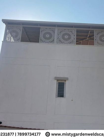 An exterior view of the completed CNC designer frame installation. The white panels add a clean, modern facade to the building's upper level, enhancing its architectural appeal.