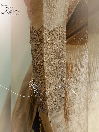 A close-up of the sleeve of our net kurti set. This image highlights the intricate sequin and pearl detailing, showcasing the delicate craftsmanship that goes into our lighter, more contemporary pieces.