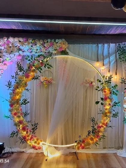 An alternate view of the lit ring backdrop, showing how it serves as the central focus of the room. This setup works well in banquet halls with wooden flooring.