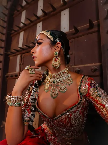 Jewellery is the soul of a bridal look. Here, I focused on layering magnificent jadau pieces, including a statement choker, earrings, and maang tikka, to complement the rich red lehenga and create a truly unforgettable bridal portrait.