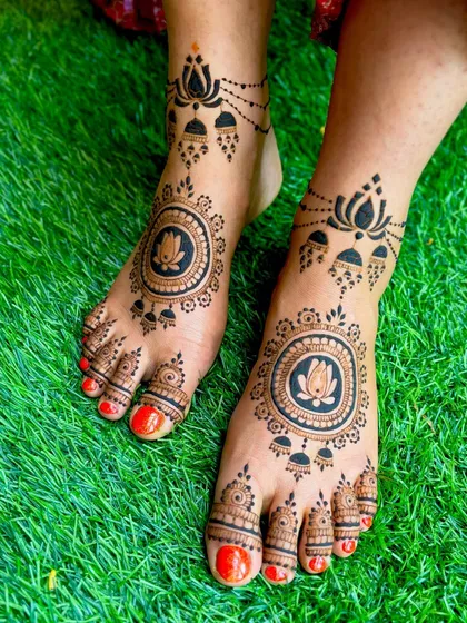 A bold and beautiful feet mehendi design, featuring a prominent lotus mandala at the center, complemented by hanging jhumka (bell) motifs for a traditional yet striking look.