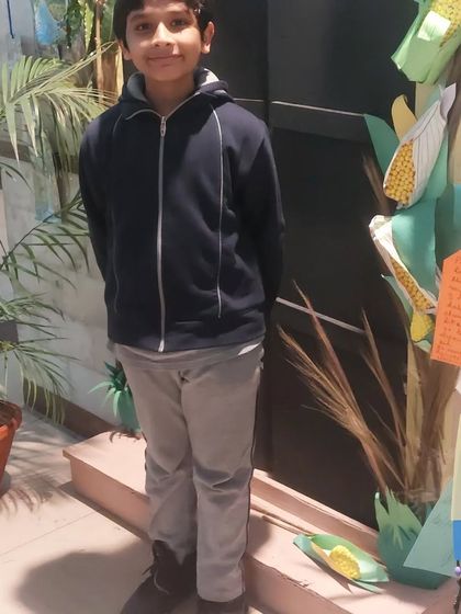 Posing proudly next to a corn-themed display at the school science fair. These events are a great way for kids to share what they've learned with a wider audience.