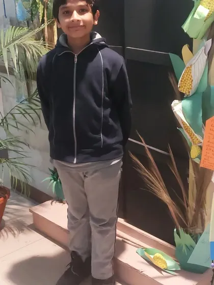 Posing proudly next to a corn-themed display at the school science fair. These events are a great way for kids to share what they've learned with a wider audience.