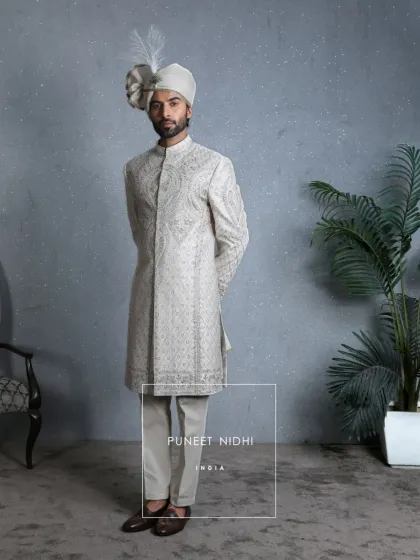 A straight-on view of the ivory silk sherwani, allowing the intricate paisley and floral resham embroidery to take center stage. This is a look woven with grace, royalty, and tradition.
