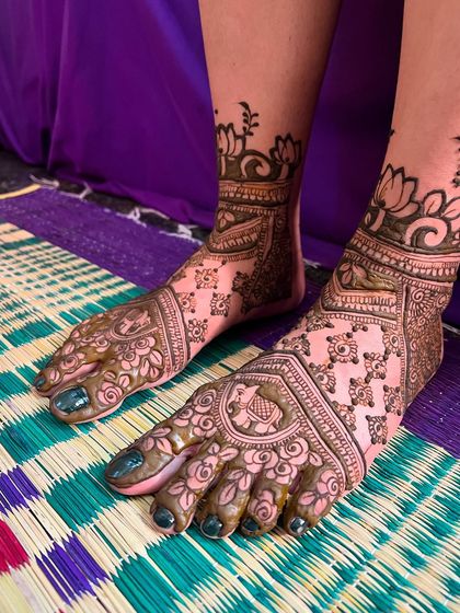 A beautiful floral foot mehendi design. This pattern includes a large lotus, elephant motifs, and delicate floral work covering the entire foot.