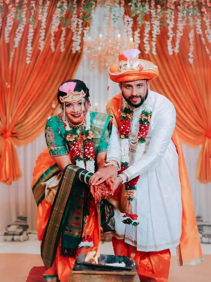 The couple performs a ritual together over the sacred fire. This photograph captures a moment of unity and tradition at the heart of their Maharashtrian wedding ceremony.