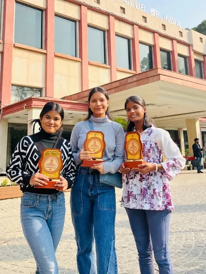 Three of my students proudly holding their awards outside the venue.