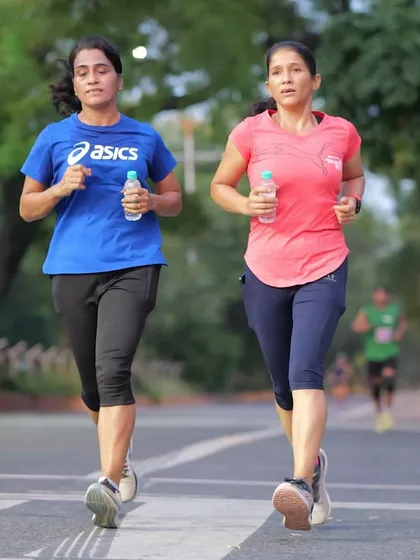 Two women running with determination during the Green Milers Run. My events are inclusive and aim to inspire people from all walks of life to stay fit.