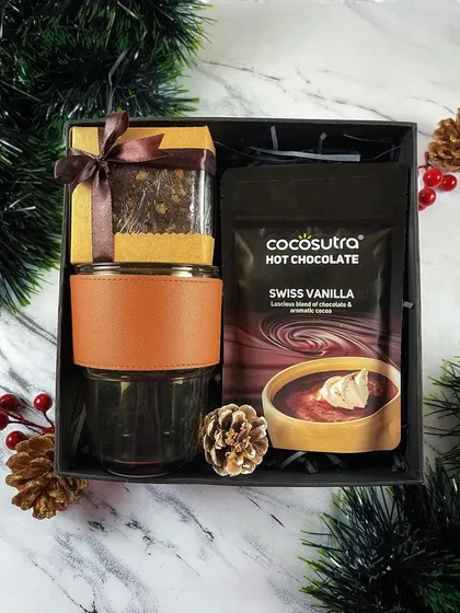 My 'Warm Wishes' hamper is designed for the holiday season. This cozy gift includes a brownie in a jar, a tumbler with a leather sleeve, and a pack of delicious hot chocolate mix.