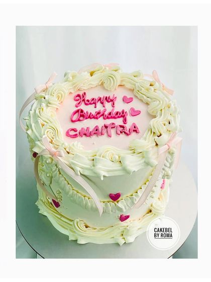 A charming vintage-style cake with delicate piping and pink ribbons for Chaitra's birthday.