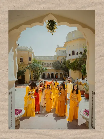 The bride's grand entrance with her family and friends, all dressed in shades of yellow for the Haldi ceremony.