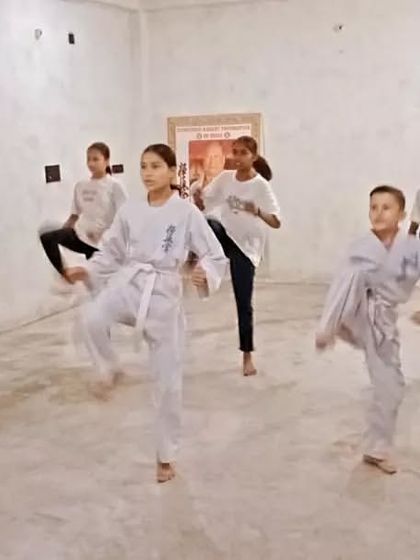 The entire line is practicing kicks together. This builds stamina and uniformity.