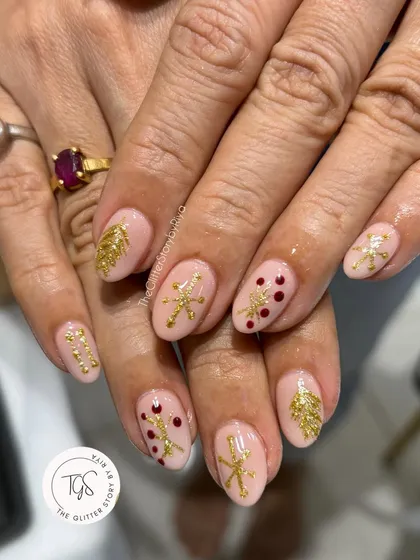 An elegant holiday set with a nude base and hand-painted gold Christmas trees and snowflakes, accented with tiny red dots.