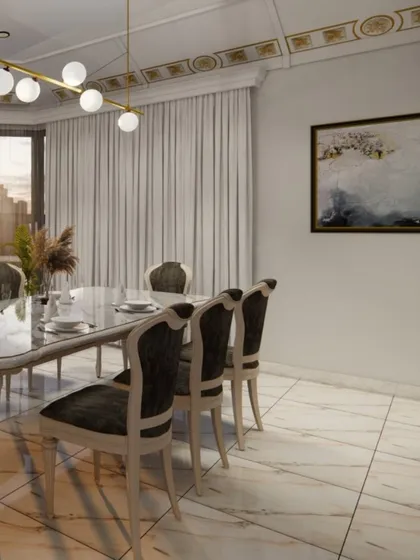 The dining space within a luxurious home, featuring a marble-top table and high-backed upholstered chairs. A modern globe chandelier and gold-accented ceiling trim add a layer of contemporary elegance to the room.