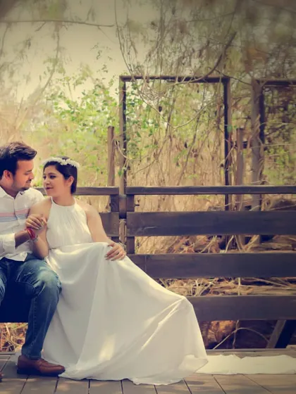 A serene and romantic pre-wedding photo of a couple sharing a quiet moment on a wooden bench.