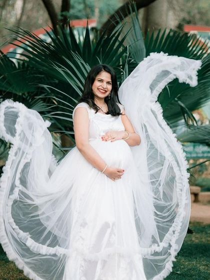 A stunning portrait featuring a flowing white gown with fabric tossed to create a dramatic wing-like effect. This technique adds movement and a touch of magic to outdoor shots.