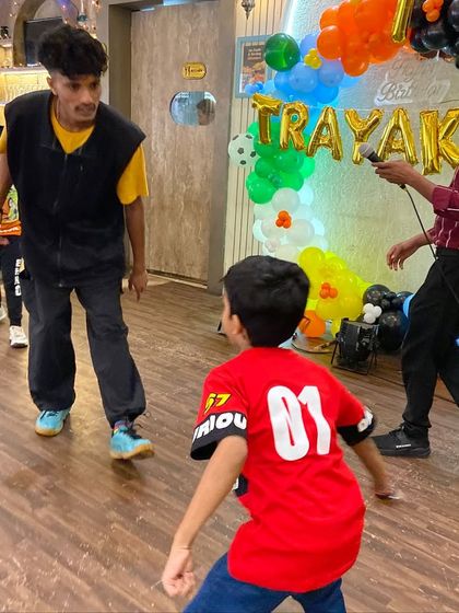A coach leads a dance and movement game indoors. We use a variety of activities to keep things fresh and exciting, ensuring there's something for every child to enjoy.