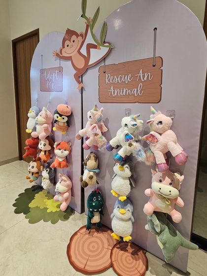 An interactive "Rescue An Animal" party favor display from a jungle-themed party. Young guests get to "adopt" a stuffed animal to take home.