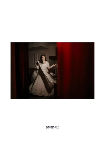 A wide shot of Shalini, her silhouette framed by a doorway, adding a sense of drama and anticipation.