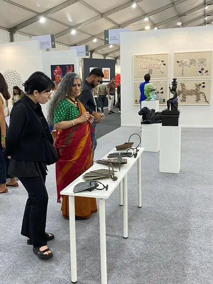 Visitors examining the sculptures and works on paper.