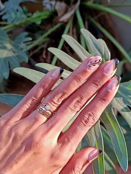 This design is the definition of chic. It features a nude base with a modern, asymmetric black French tip, highlighted by a delicate gold chrome line and a hand-painted leaf design. It shows how I combine different techniques for a sophisticated result.