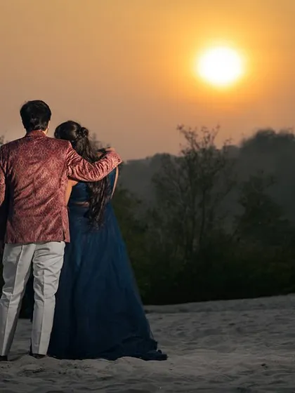 Watching the sunset together. This simple, timeless pose captures a shared moment of peace and beauty, a perfect memory from their pre-wedding shoot.