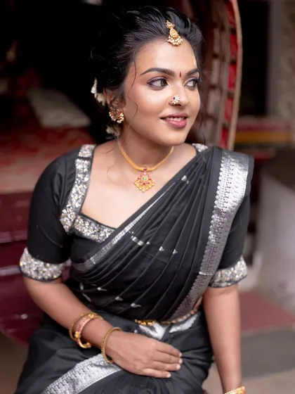 Bold and beautiful in a black saree. This look proves that dusky skin can carry bold colors with incredible elegance. The makeup is kept warm and glowing.