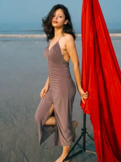 A full-body shot that showcases the model's pose and the elegant dress, with the red fabric adding a vibrant, eye-catching detail.