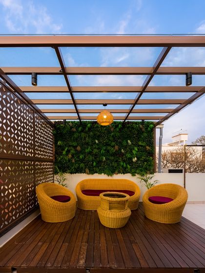 Your balcony deserves to be a mood. This design features a vertical green wall, comfortable rattan furniture, and a glass-paneled pergola, creating an urban oasis perfect for enjoying the skyline.