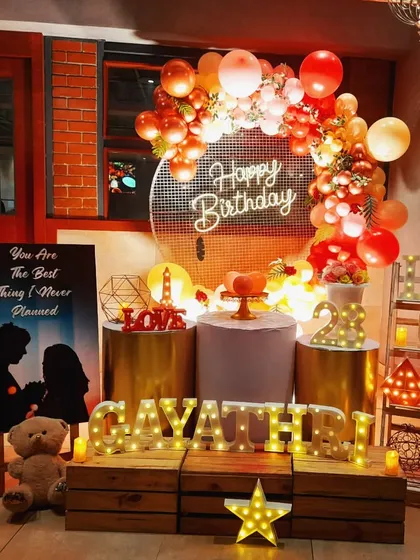 I designed this romantic birthday surprise for Gayathri. The setup features a warm, inviting color palette with a sequin backdrop, a custom silhouette poster, and lots of marquee lights spelling out her name and the word "LOVE" to create a truly personal and heartfelt atmosphere.