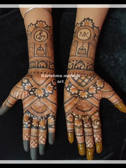 A beautiful engagement mehendi featuring the couple's initials, "M" and "K", in stylish monograms. The design also includes symbols of commitment like temple domes and elephants, perfect for celebrating a new beginning.