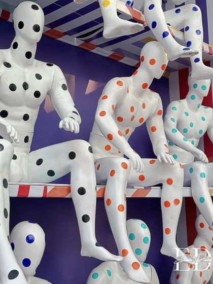 A detailed shot of the colorful, polka-dotted mannequin installation, highlighting the playful yet artistic execution.